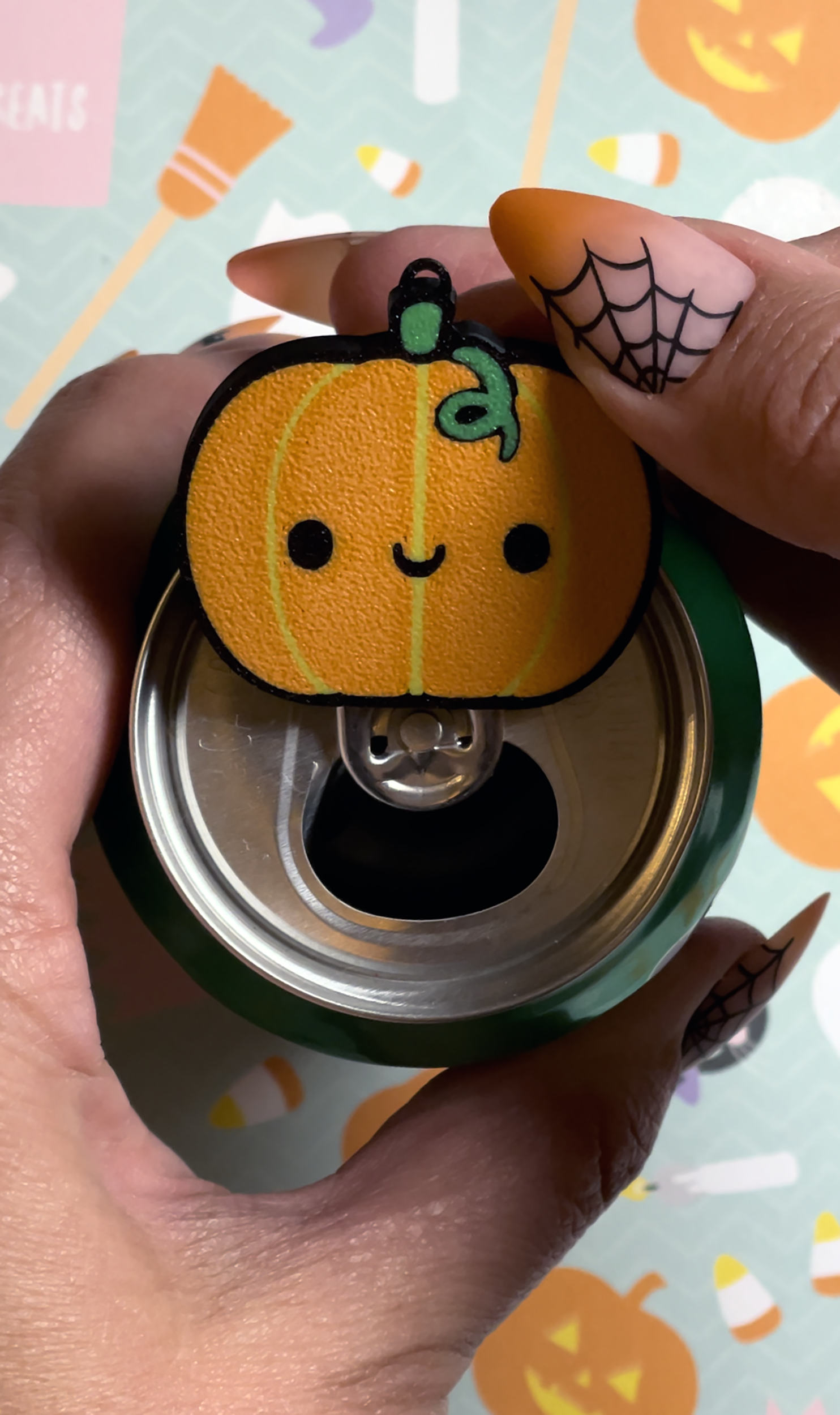 Pumpkin-shaped Tab Buddy held by a hand with Halloween-themed background