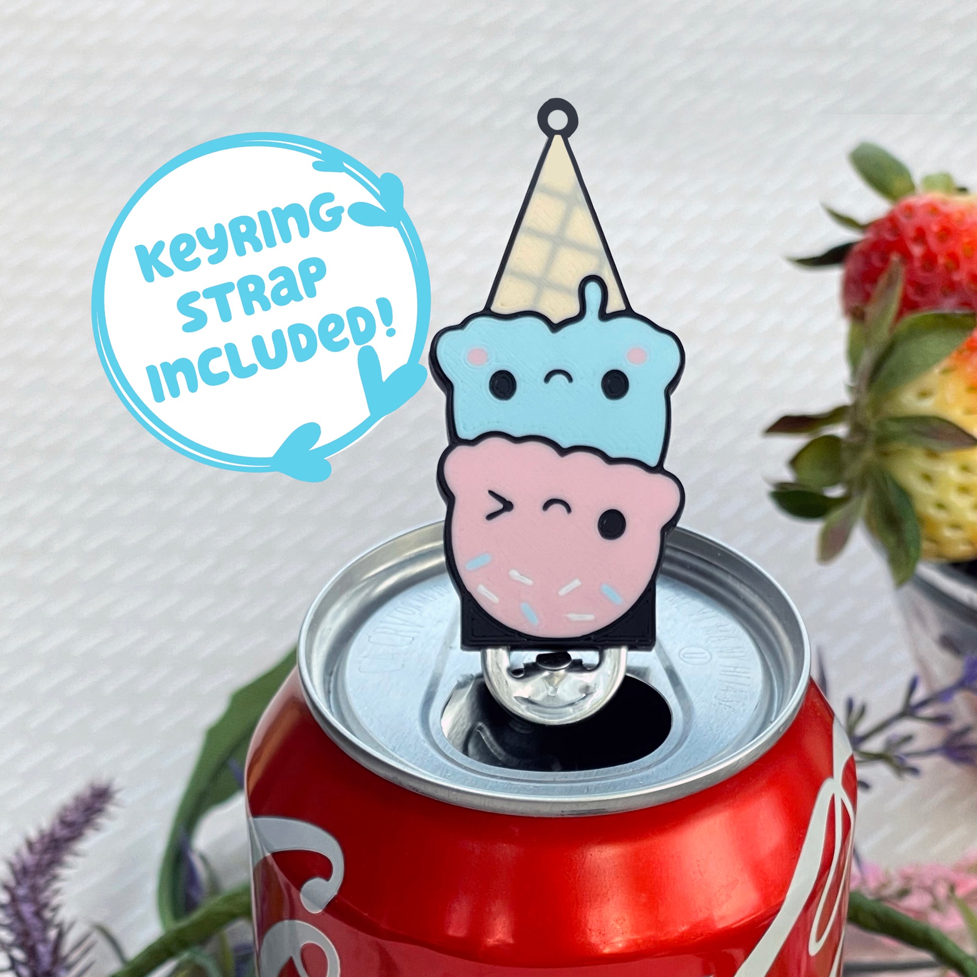 Cute ice cream cone Tab Buddy with keyring strap rests atop a Coca-Cola can with beige background