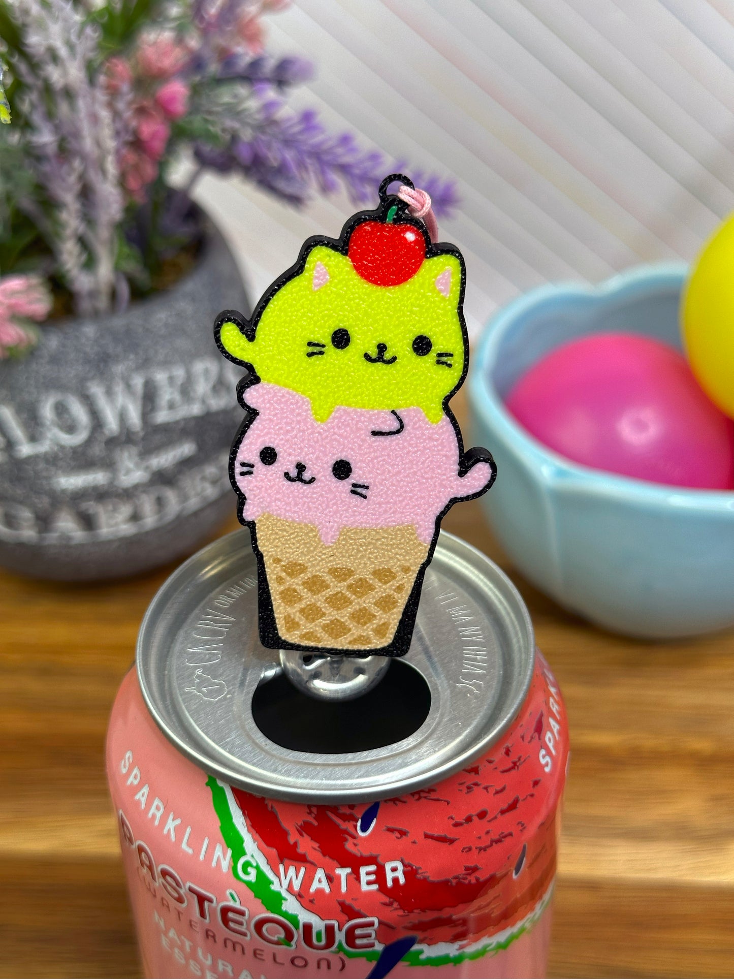 Cute cat-themed ice cream cone Tab Buddy on a can of sparkling water with a blurred background.