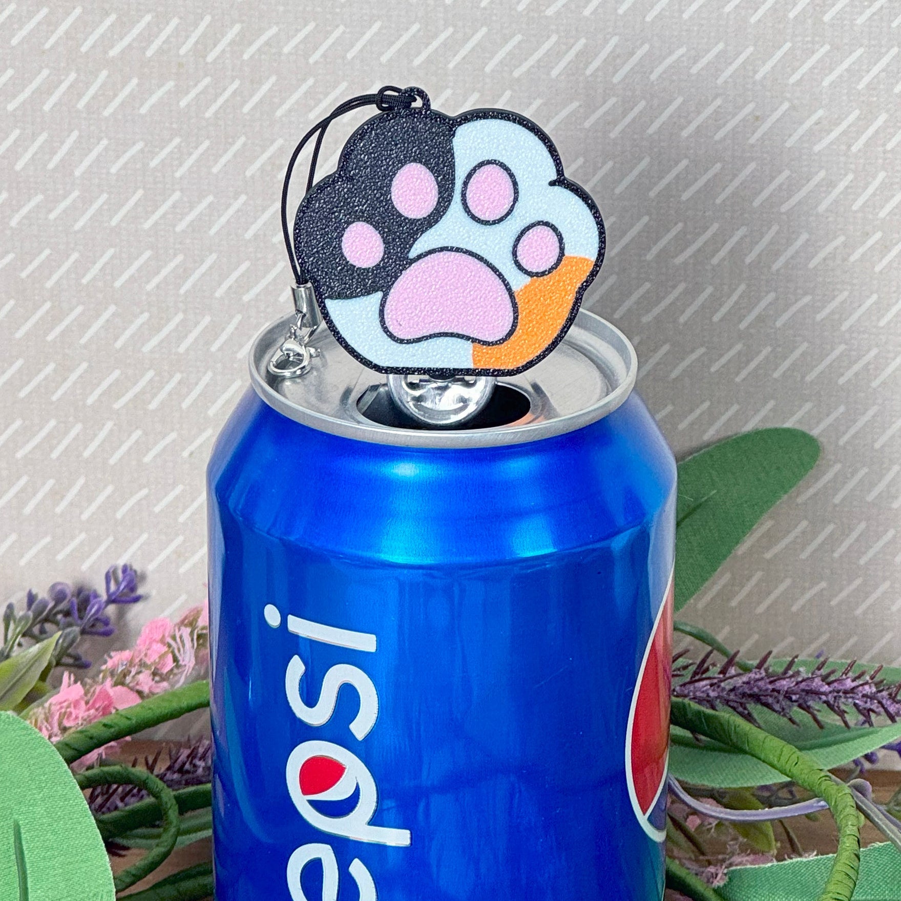 Can with a paw print Tab Buddy on a textured gray background