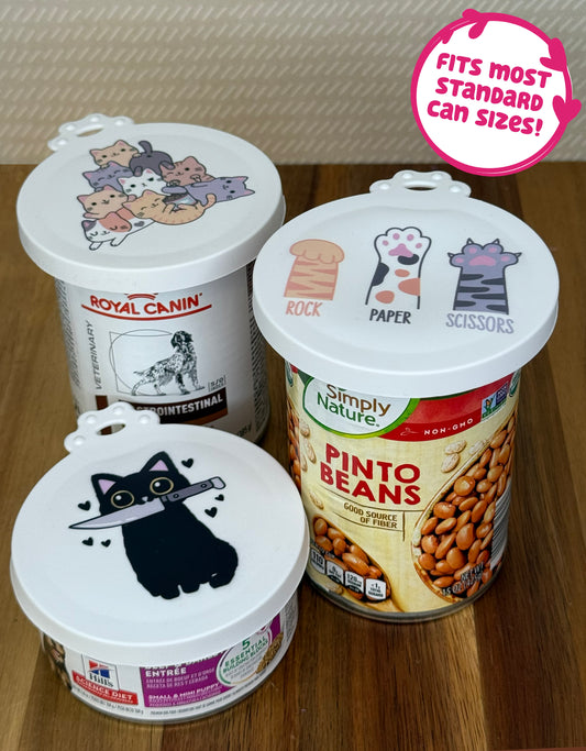Three food cans of vearious types and sizes are shown with cat-themed resusable can lids sealing their tops. Text bubble reads, "Fits most standard can sizes!"