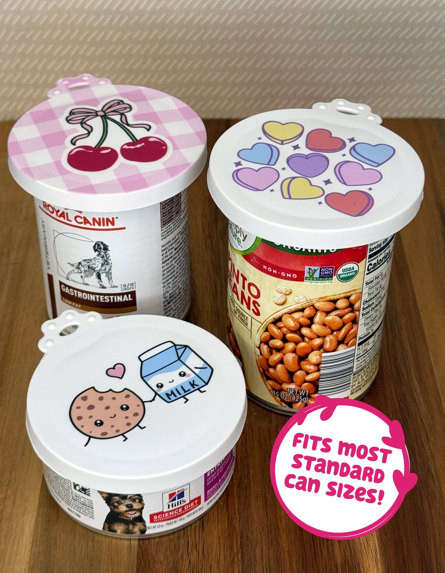 Three food cans of vearious types and sizes are shown with food-themed resusable can lids sealing their tops. Text bubble reads, "Fits most standard can sizes!"