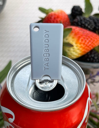 Grey Tab Buddy Mini can opener on a Coca-Cola can with berries in the background