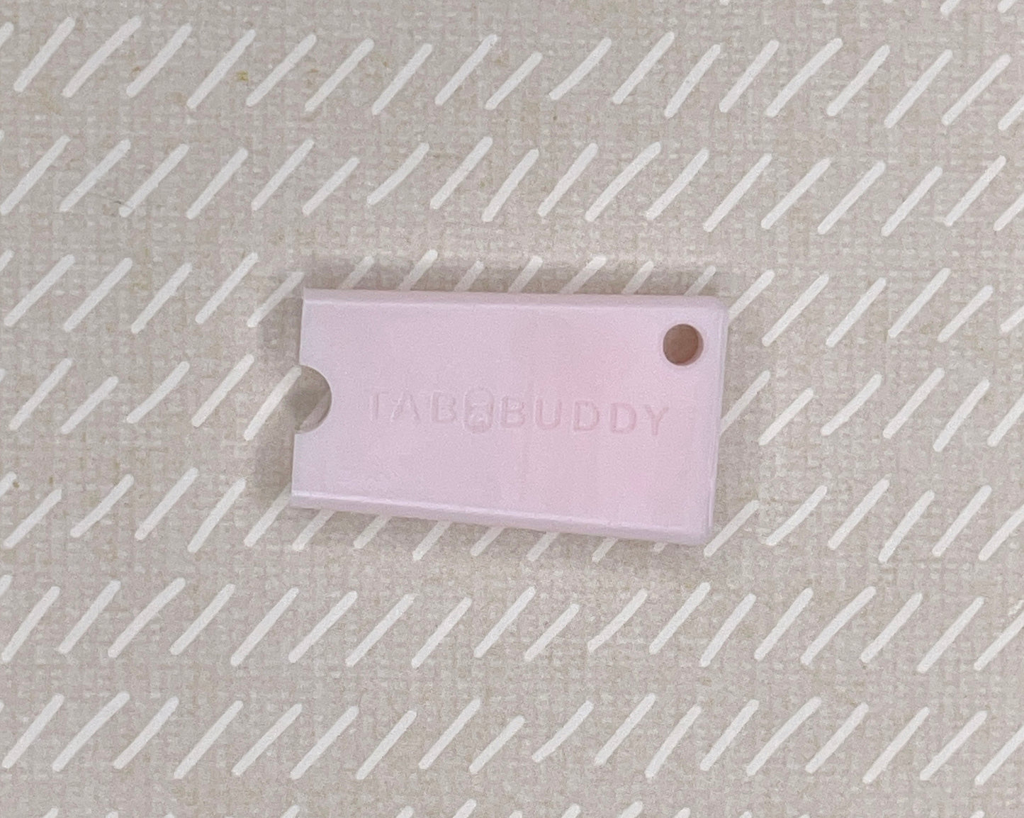 Pink Tab Buddy Mini on a textured beige background