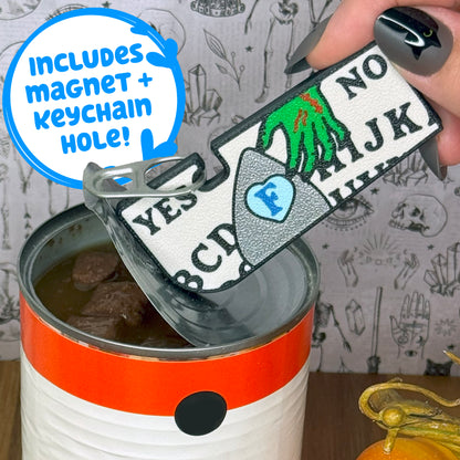 Ouija-themed Tab Buddy XL with magnet and keyring hole is used to open a can