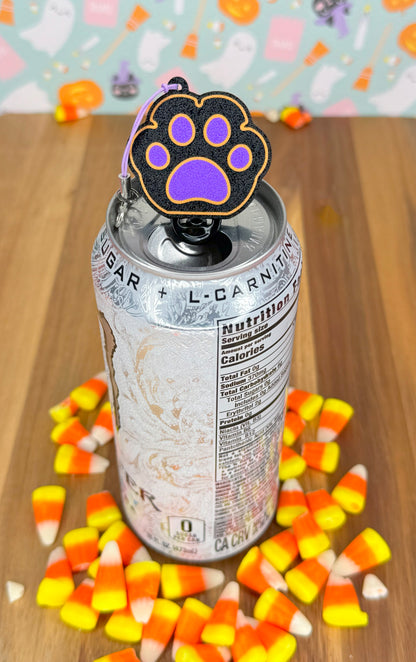 Can with a halloween themed paw-shaped Tab Buddy on a wooden surface with candy corn