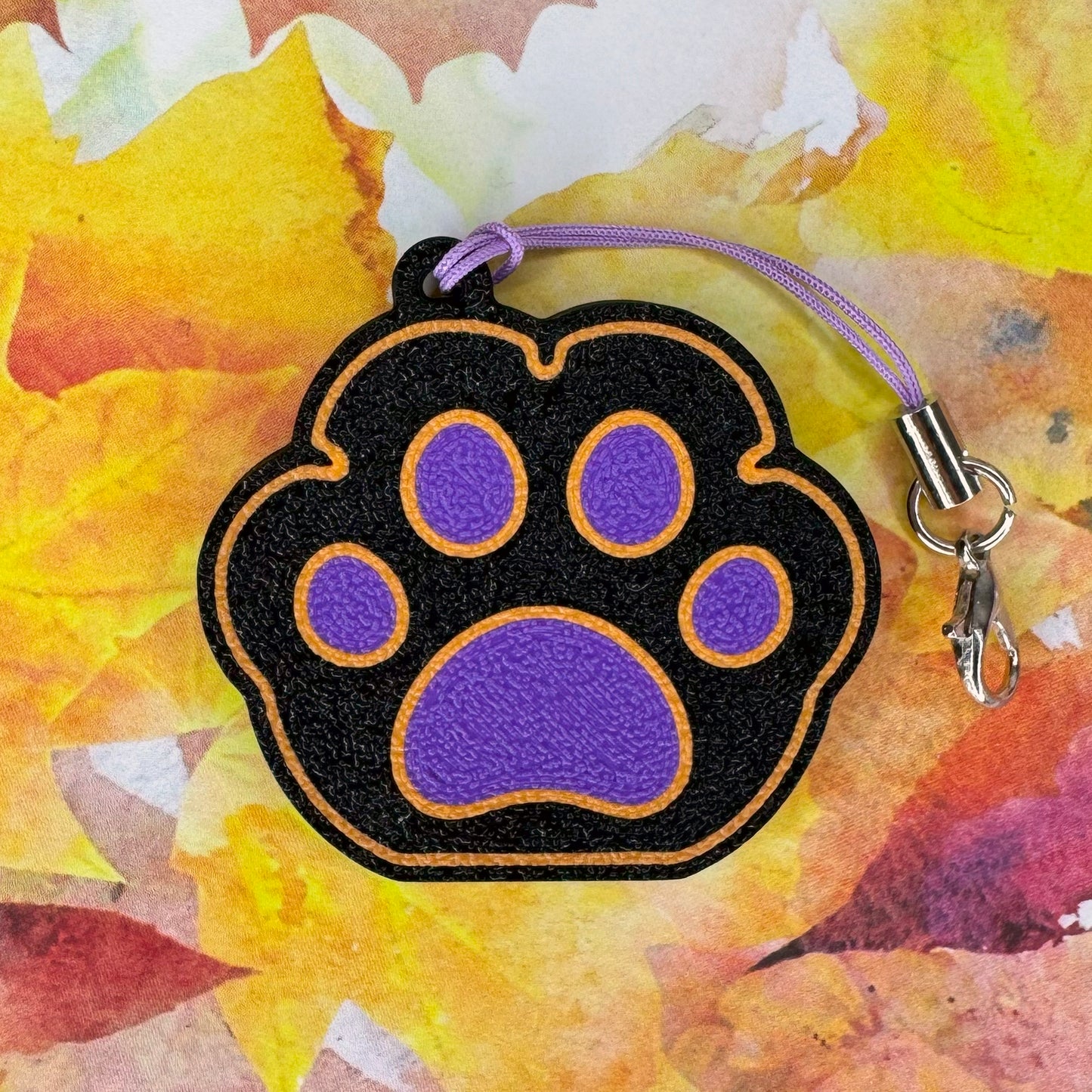 Halloween themed paw shaped Tab Buddy on a colorful leaf background