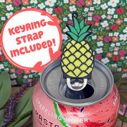 Pineapple-shaped Tab Buddy with keyring strap on a can with floral background