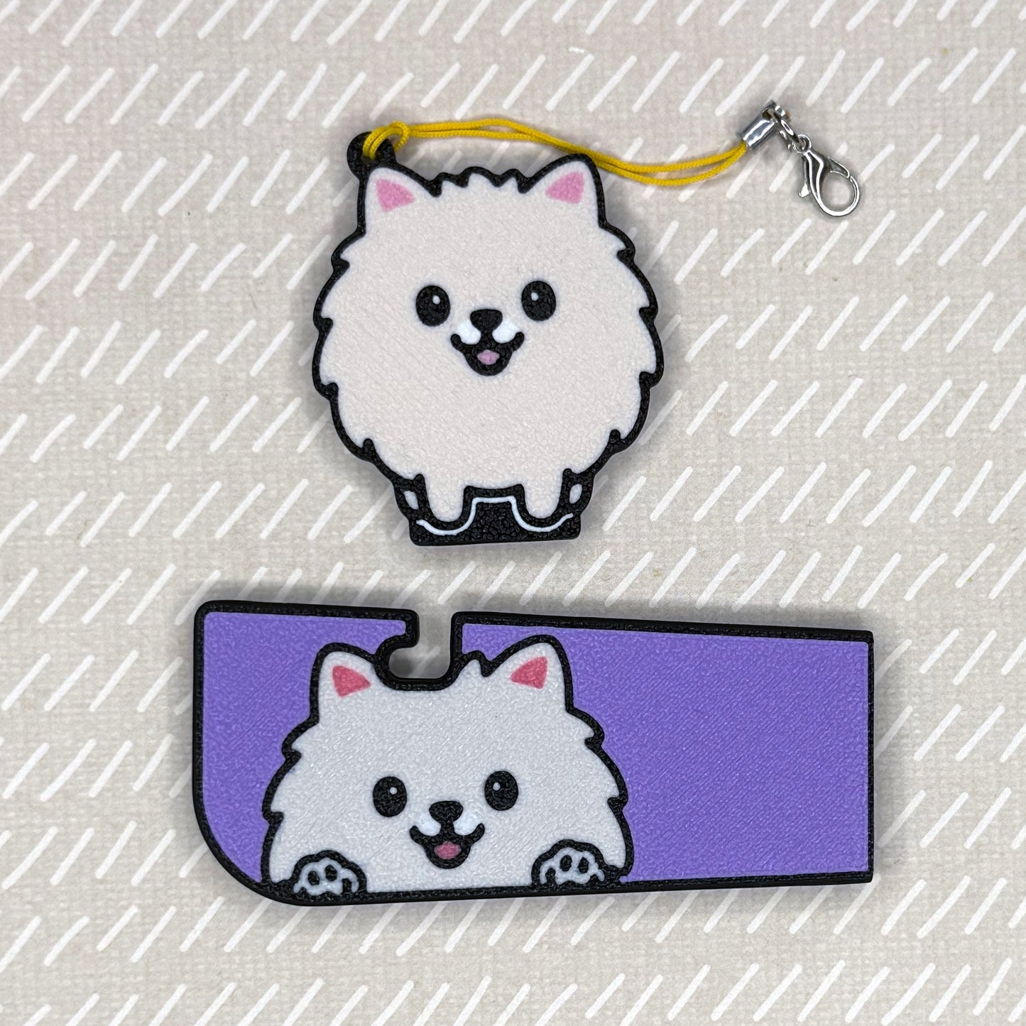 A Pomeranian dog-design Tab Buddy XL and matching soda-sized Tab Buddy rest atop a beige surface.