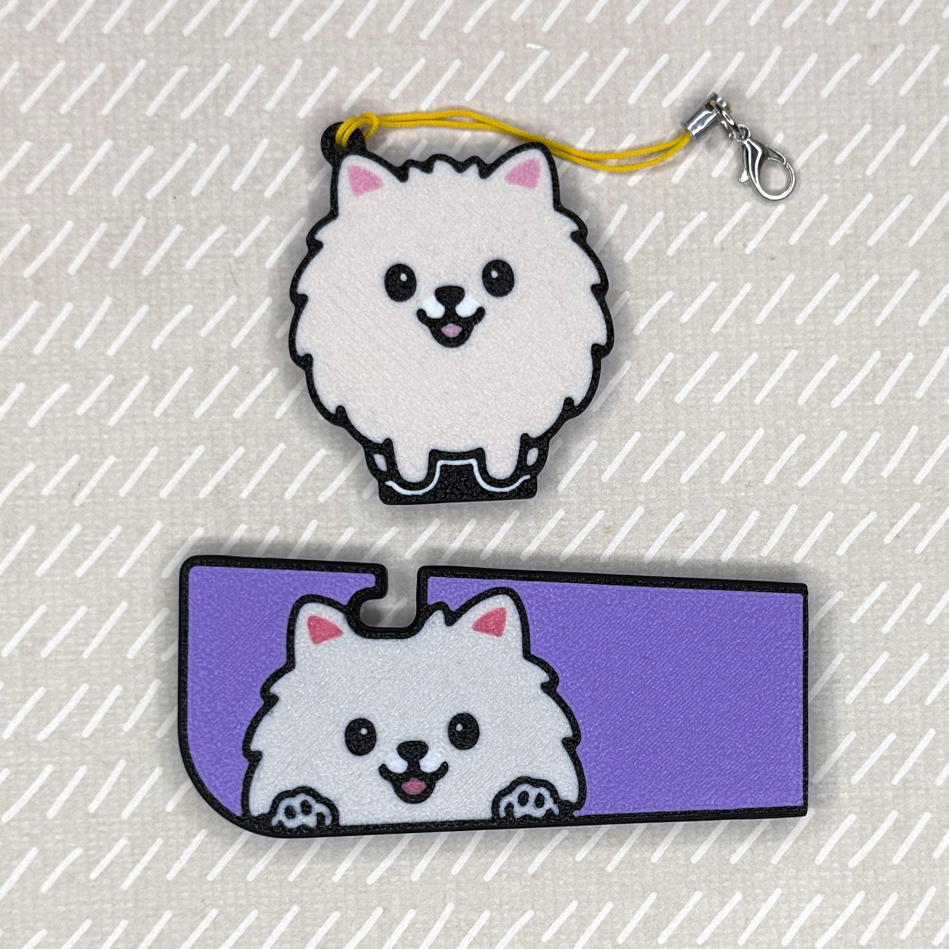 A Pomeranian dog-design Tab Buddy XL and matching soda-sized Tab Buddy rest atop a beige surface.
