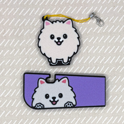 A Pomeranian dog-design Tab Buddy XL and matching soda-sized Tab Buddy rest atop a beige surface.