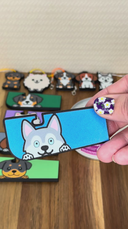 A Tab Buddy XL is shown lifting the tab of a can of dog food, then peeling back the lid. A smaller Tab Buddy is shown opening an energy drink can. Various dog designs of both sizes are shown.