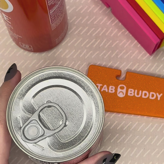 A turquoise Tab Buddy XL is used to lift the tab, then peel back the lid on a can of chipotle peppers. An Orange Tab Buddy XL then is used to pop the tab of an orange can of soda. A range of Tab Buddy XL colors then are shown.