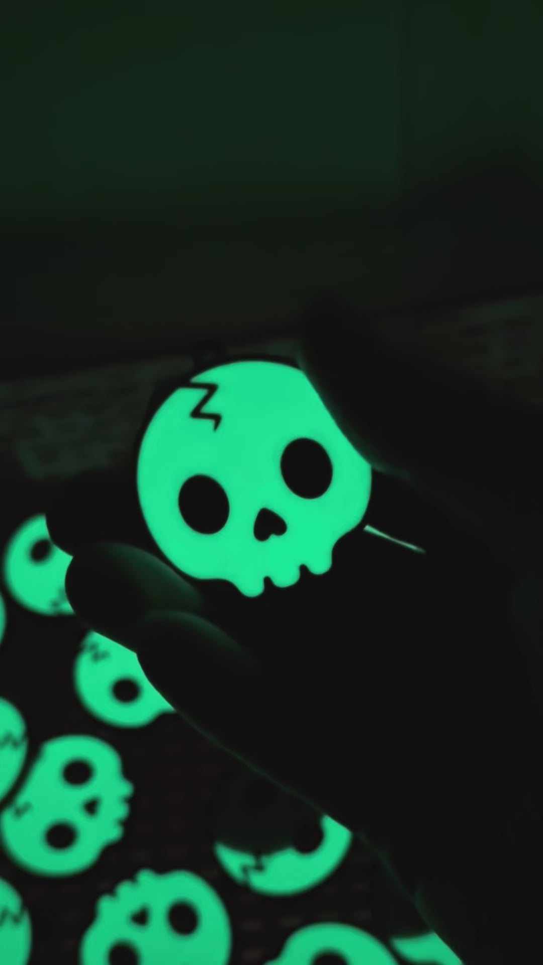 a glowing skull Tab Buddy is shown in the dark, then transitions to appearing green under regular light before opening a black Monster can. Other skull design Tab Buddies also are shown.
