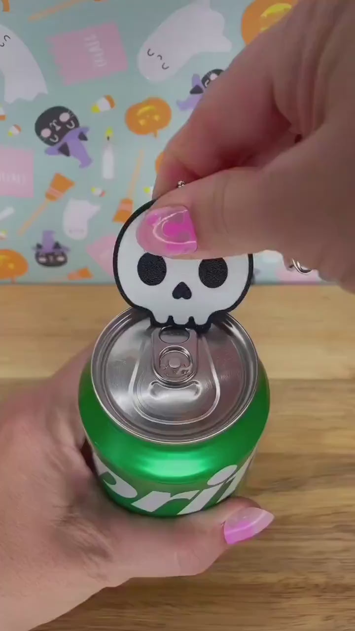 A white skull Tab Buddy is used to open a green can of Sprite. A Candy corn themed Tab Buddy then opens a red can of Coca-Cola. Subsequent images show other related Halloween-themed Tab Buddies designs.