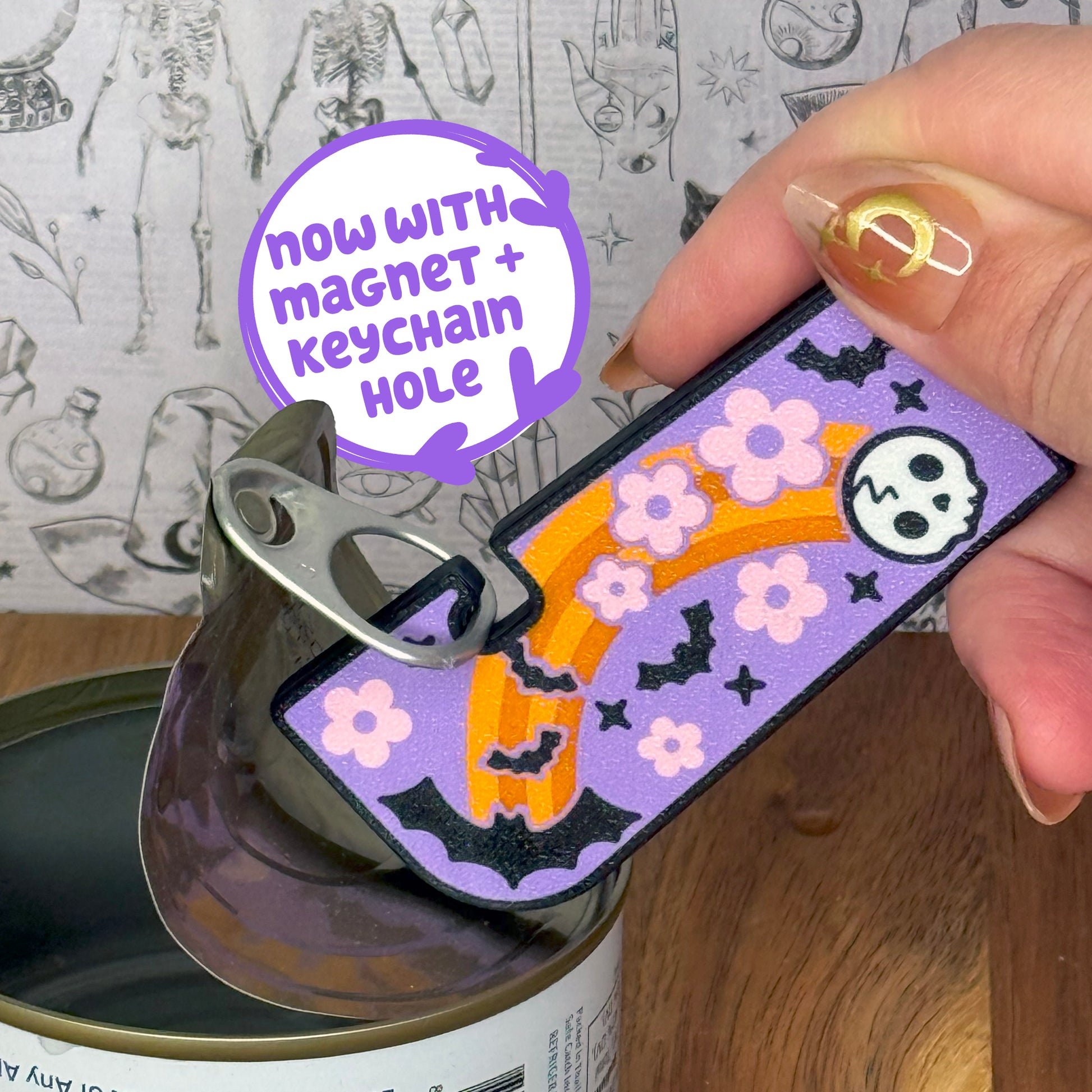 Decorative Tab Buddy XL keychain with magnet and keychain hole feature, held over a can.