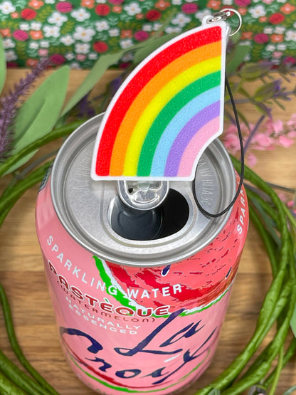 Pink can of sparkling water with a rainbow-themed Tab Buddy with strap on a floral background