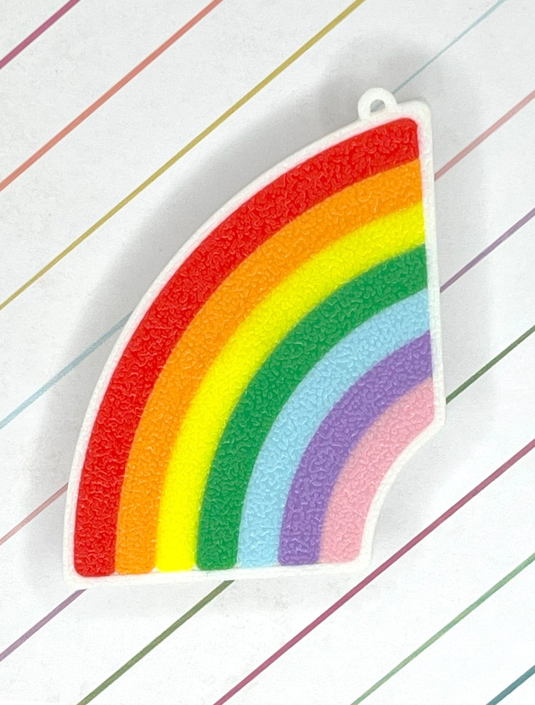 Curved rainbow-shaped Tab Buddy on a striped background
