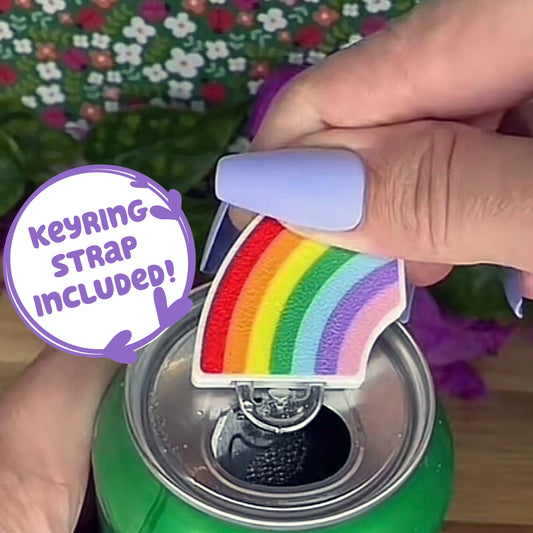 Person using a rainbow Tab Buddy to open a green can with a floral background. Text reads, "Keyring strap included."