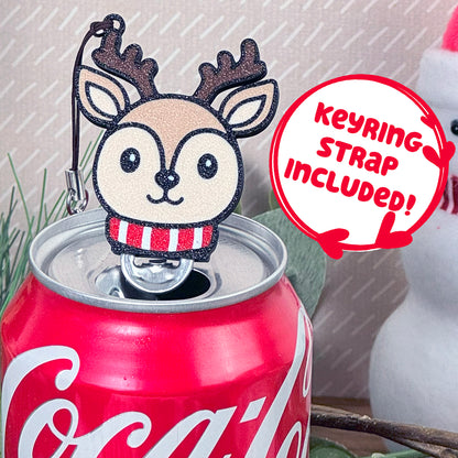 Coca-Cola can with a reindeer Tab Buddy resting on top, featuring a 'Keyring Strap Included!' text.