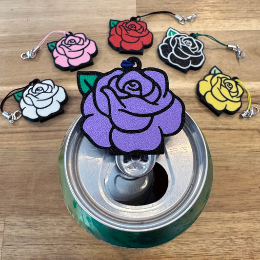 Colorful rose-shaped Tab Buddy keychains on a can with a wooden surface background