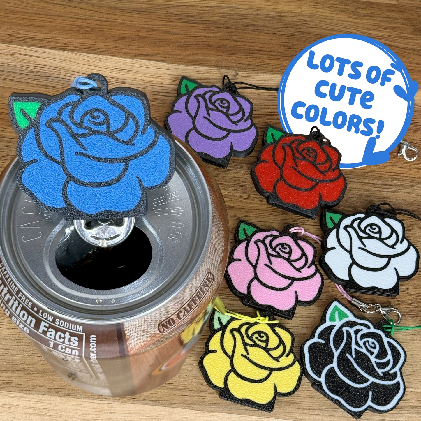 Colorful rose-shaped Tab Buddy keychains on a can with a text bubble indicating 'Lots of cute colors!'.