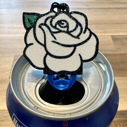Can with a white rose-shaped Tab Buddy on a wooden surface