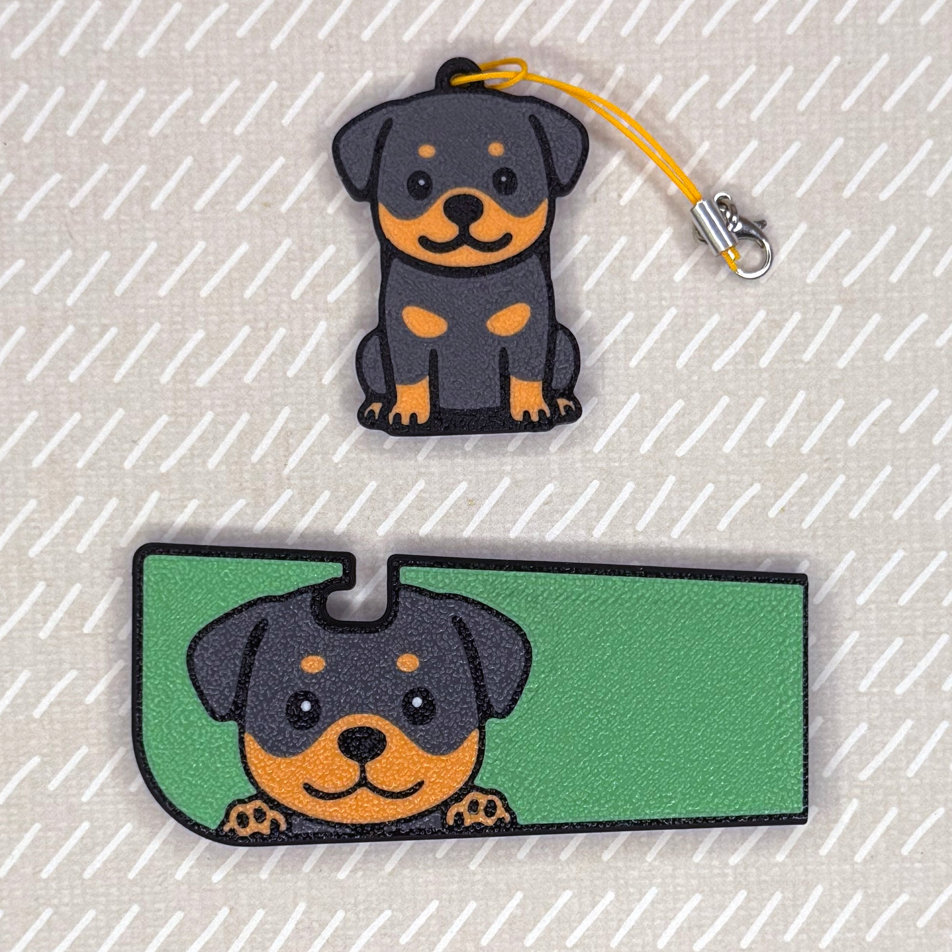 A Rottweiler dog-design Tab Buddy XL and matching soda-sized Tab Buddy rest atop a beige surface.