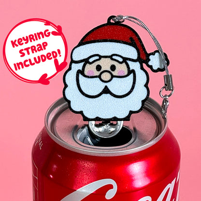 Coke can with a Santa Claus Tab Buddy keychain on a pink background. Text reads "keyring strap included."