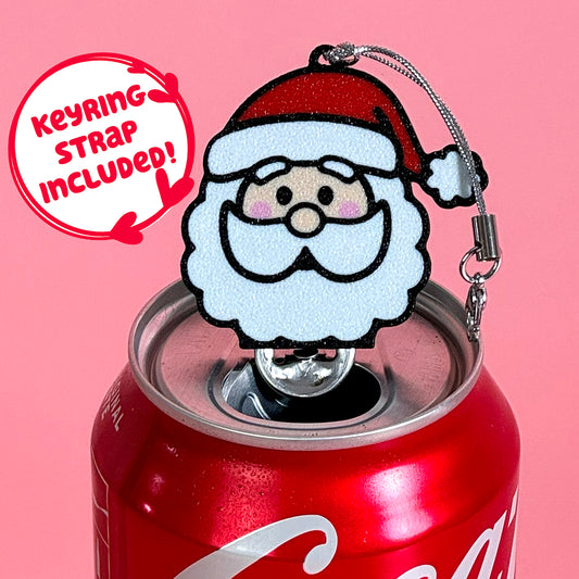 Coke can with a Santa Claus Tab Buddy keychain on a pink background. Text reads "keyring strap included."