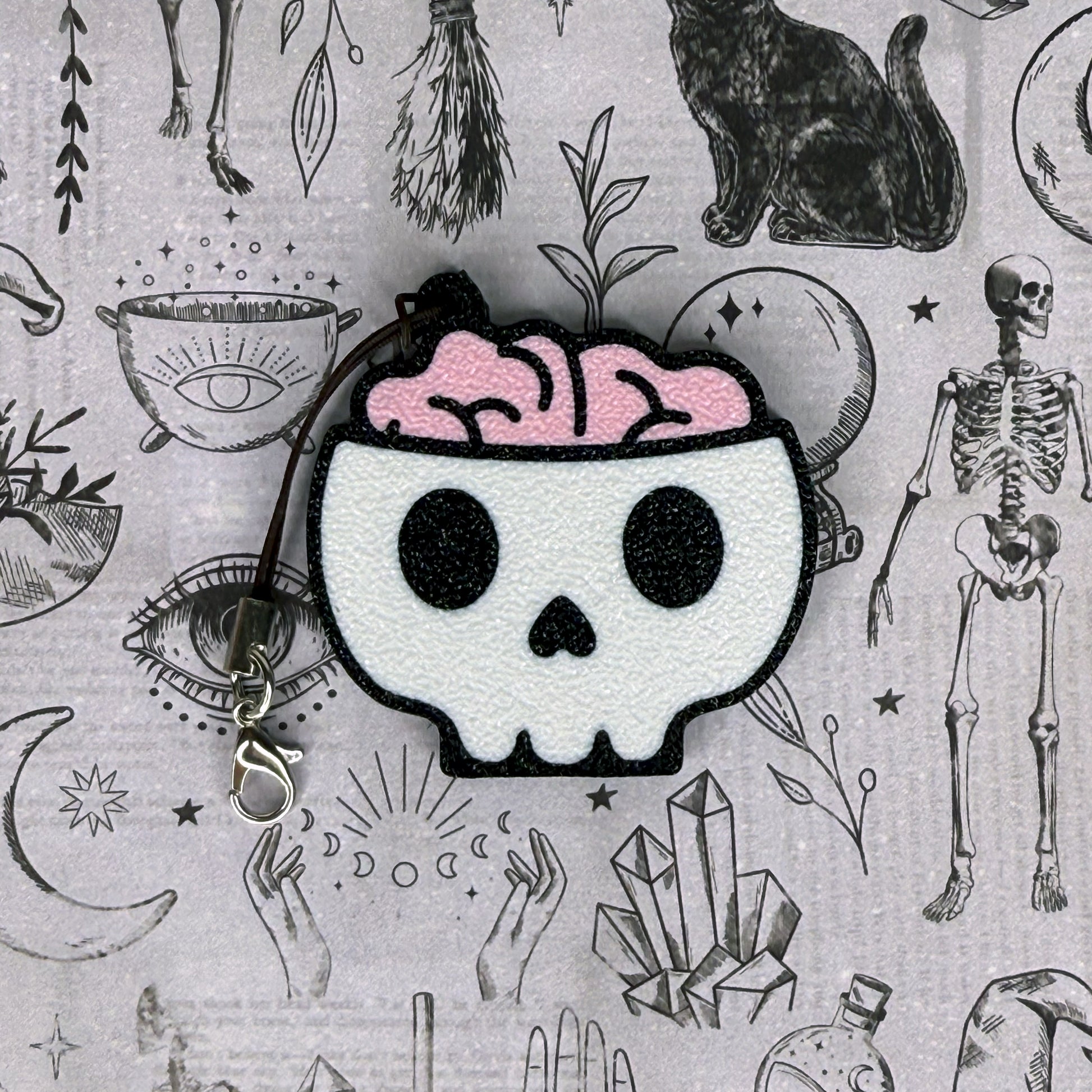 Skull Tab Buddy with pink brain on a gray background with occult symbols