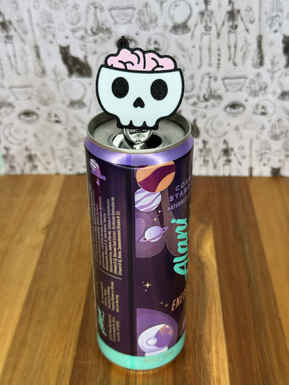 Alani can with a skull and pink brain design on top, against a patterned background