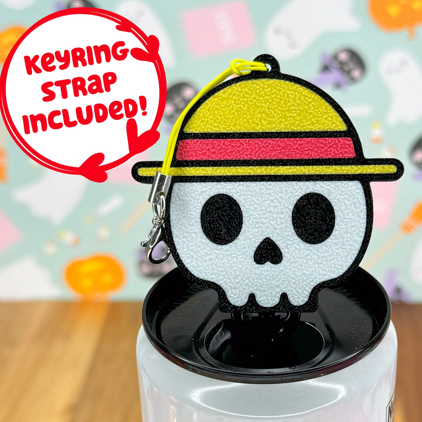 Skull wearing a straw hat-shaped Tab Buddy keychain on a white can against a colorful background.