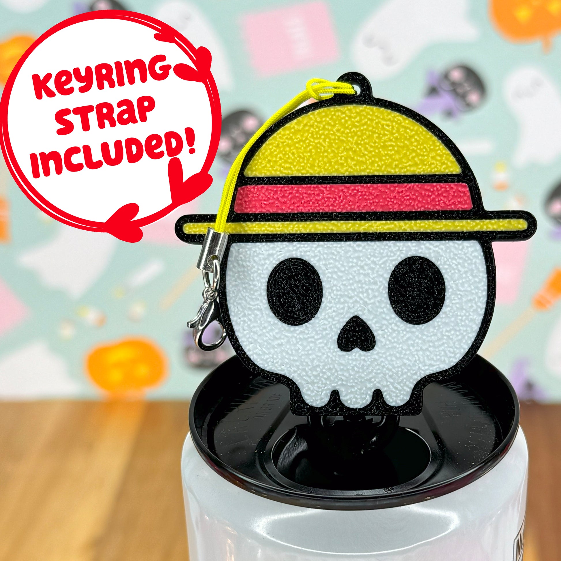 Skull wearing a straw hat-shaped Tab Buddy keychain on a white can against a colorful background.