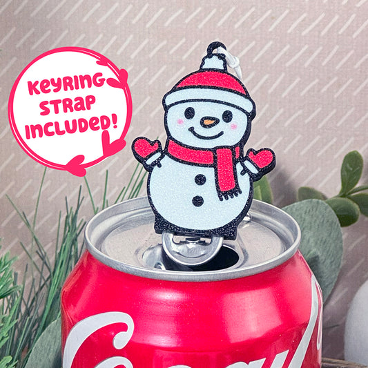 Snowman Tab Buddy with keyring strap included on a Coca-Cola can with plants in the background