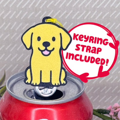 A Yellow Lab-inspired Tab Buddy rests atop an open can tab. Desecriptive text reads "Keyring Strap Included!"