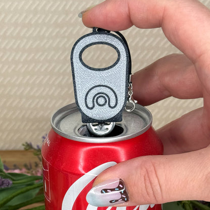 Hand holding a Tab Buddy over a Coca-Cola can with a blurred background
