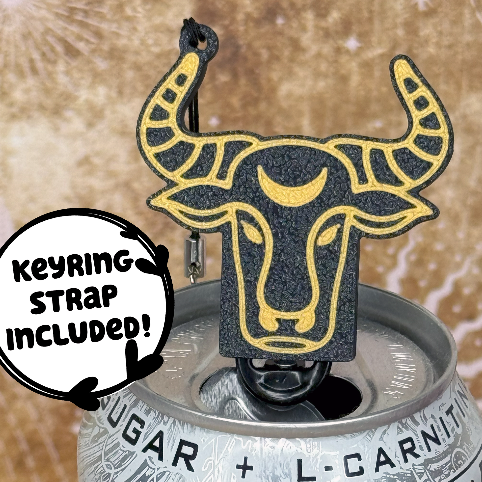 Tab Buddy keychain with Taurus Zodiac  bull design sits atop an energy drink can, featuring a keyring strap included label.