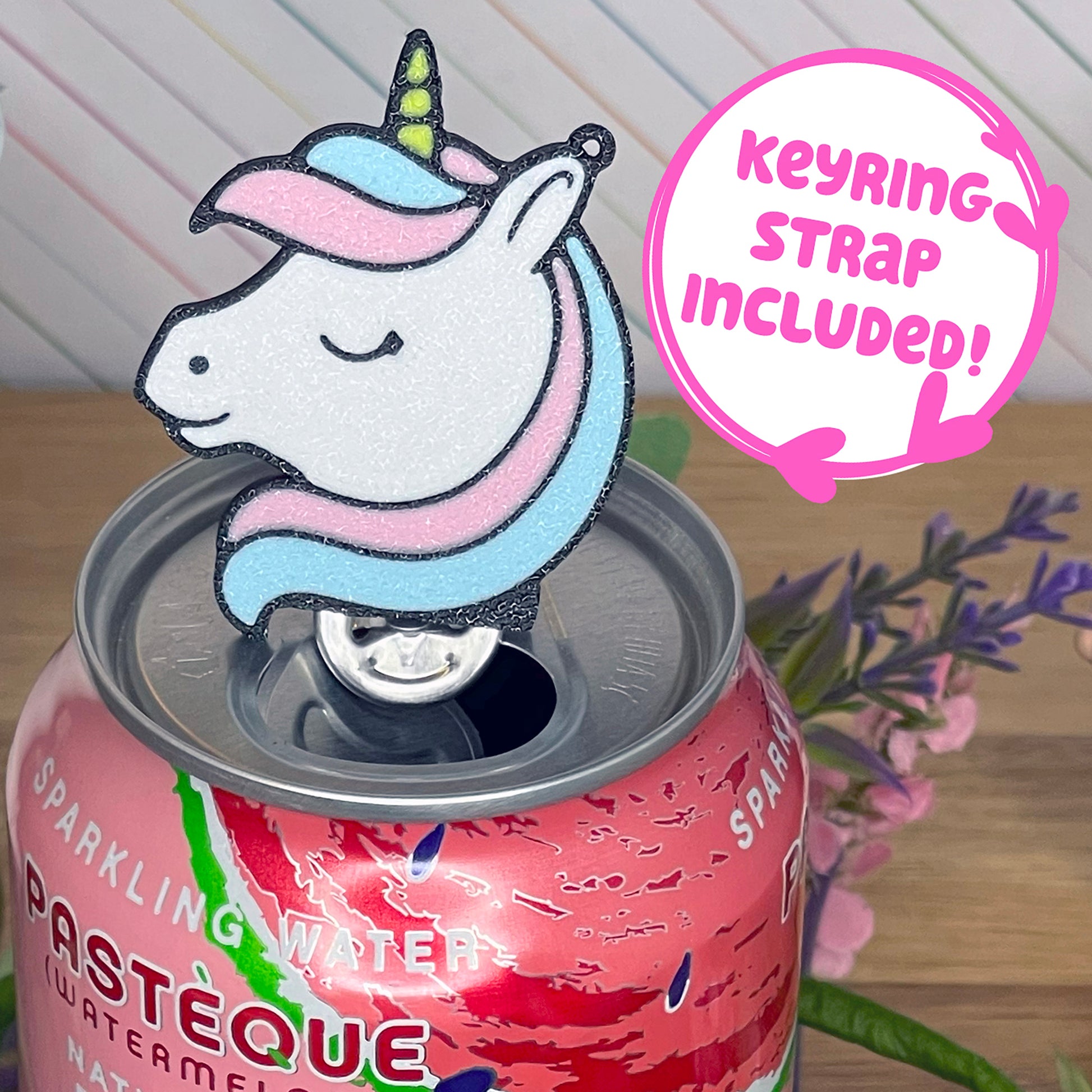 Unicorn-shaped Tab Buddy on a can with, featuring a pink background with text that reads 'keyring strap included!'