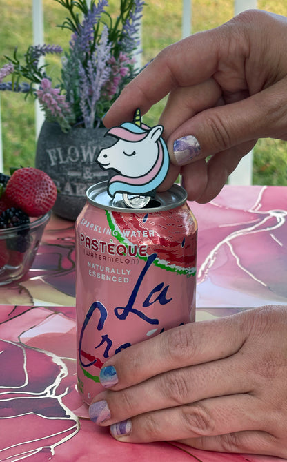 Person holding a unicorn Tab Buddy on a soda can