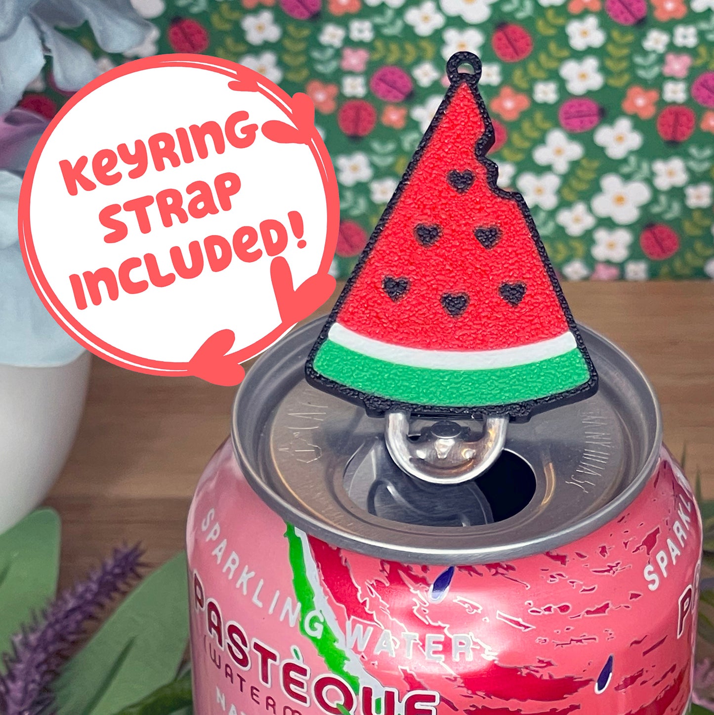 Pink can with watermelon Tab Buddy on top, against a floral background with text that reads 'keyring strap included'