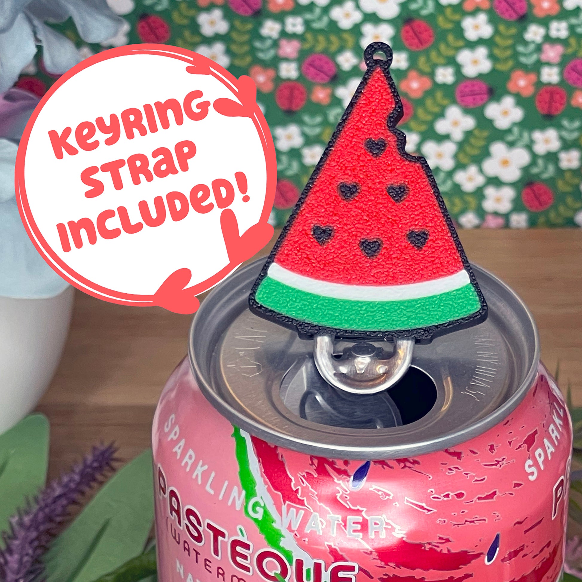 Pink can with watermelon Tab Buddy on top, against a floral background with text that reads 'keyring strap included'