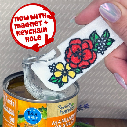 White Tab Buddy XL with Floral design of winter flowers in red, yellow and light blue is used to open a can of Sweet Harvest Mandarin Oranges. The Tab Buddy XL comes with a magnet and keychain hole.
