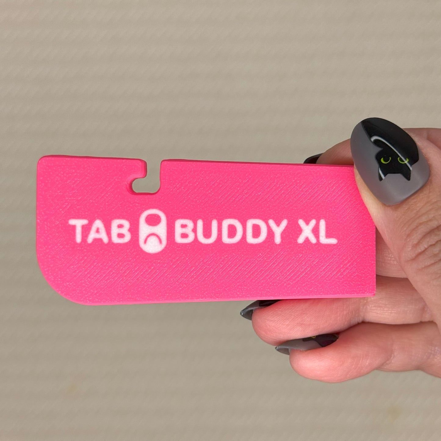 Bright Pink 'Tab Buddy XL' product held by a hand against a beige background