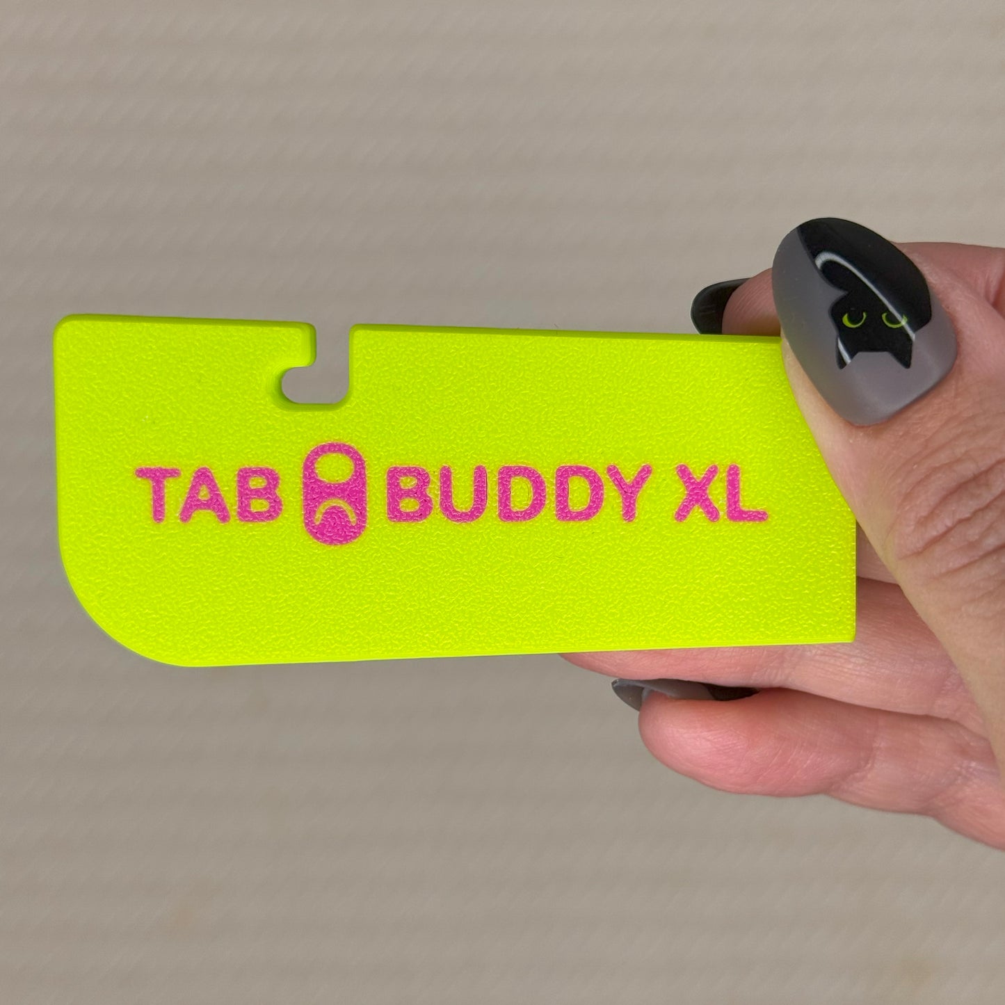 Cherry limeade color 'Tab Buddy XL' product held by a hand against a neutral background