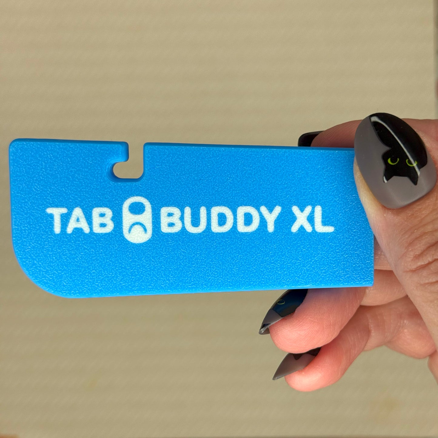 Sky Blue 'Tab Buddy XL' product held by a hand against a beige background