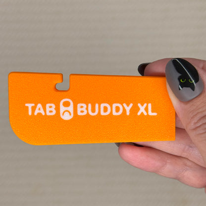 Orange 'Tab Buddy XL' product held by a hand against a neutral background