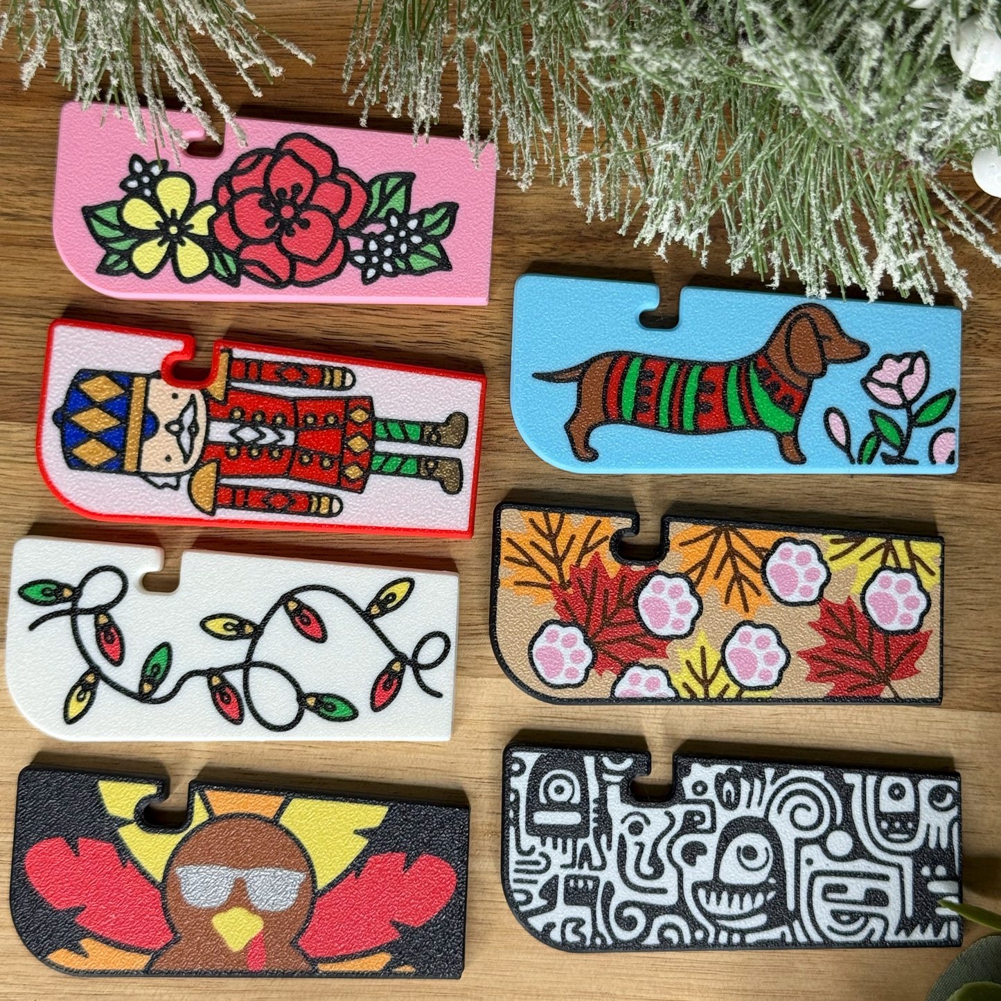Set of colorful Tab Buddy XLs with various designs on a wooden surface.