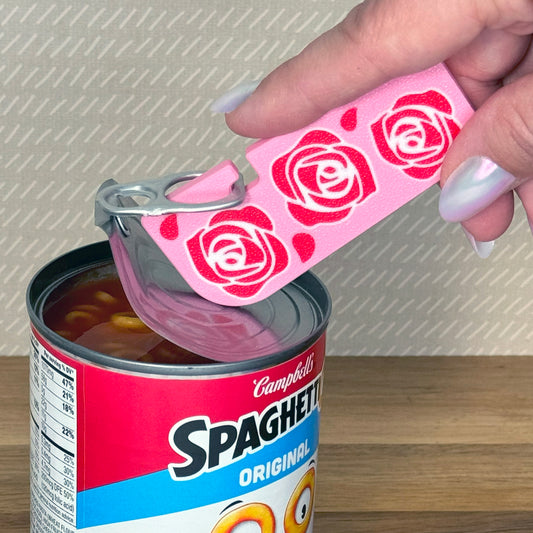 Person using a Tab Buddy XL with rose designs on a Campbell's Spaghetti-Os can.