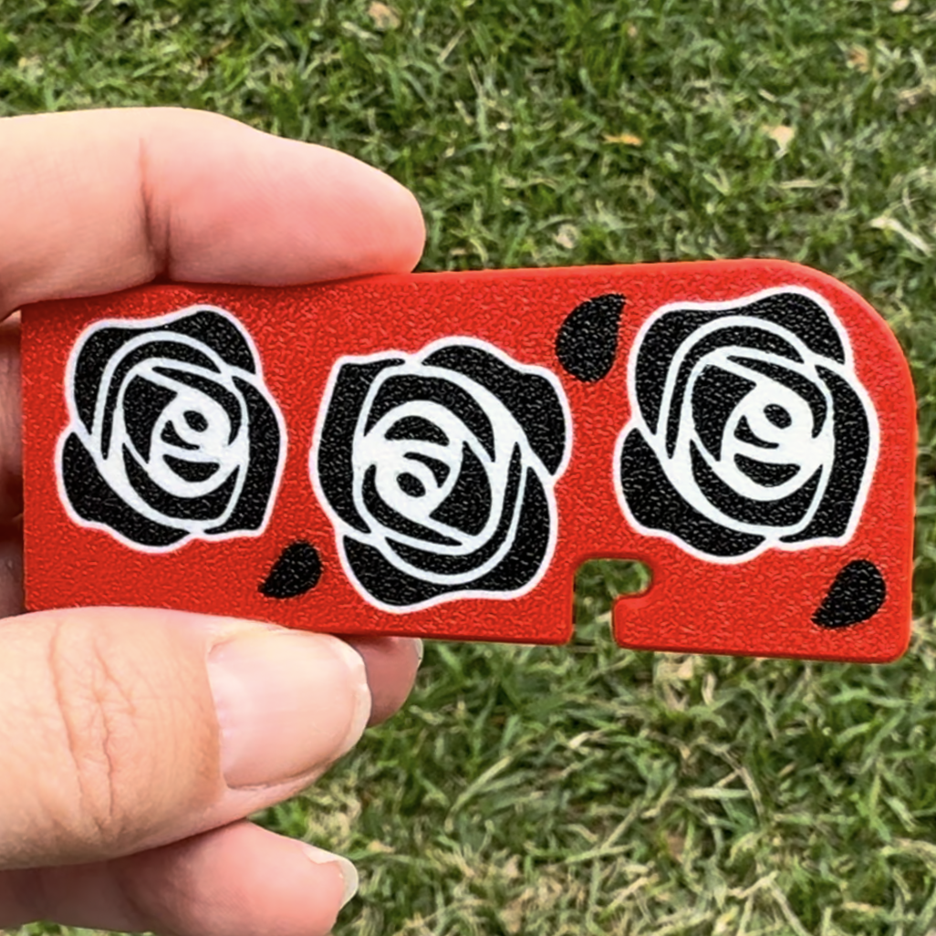 Red Tab Buddy XL with black rose designs held by a hand on grass